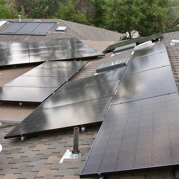 A group of solar panels on the roof of a house.